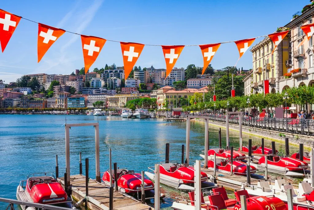 paddleboats parked near the shore in lugano, one of the most beautiful places switzerland