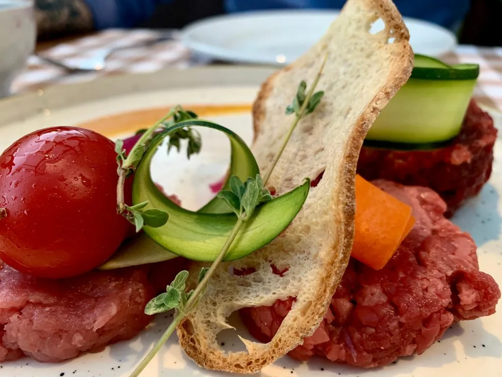 plate of horse tartare served with bread and garnish in emilia romagna