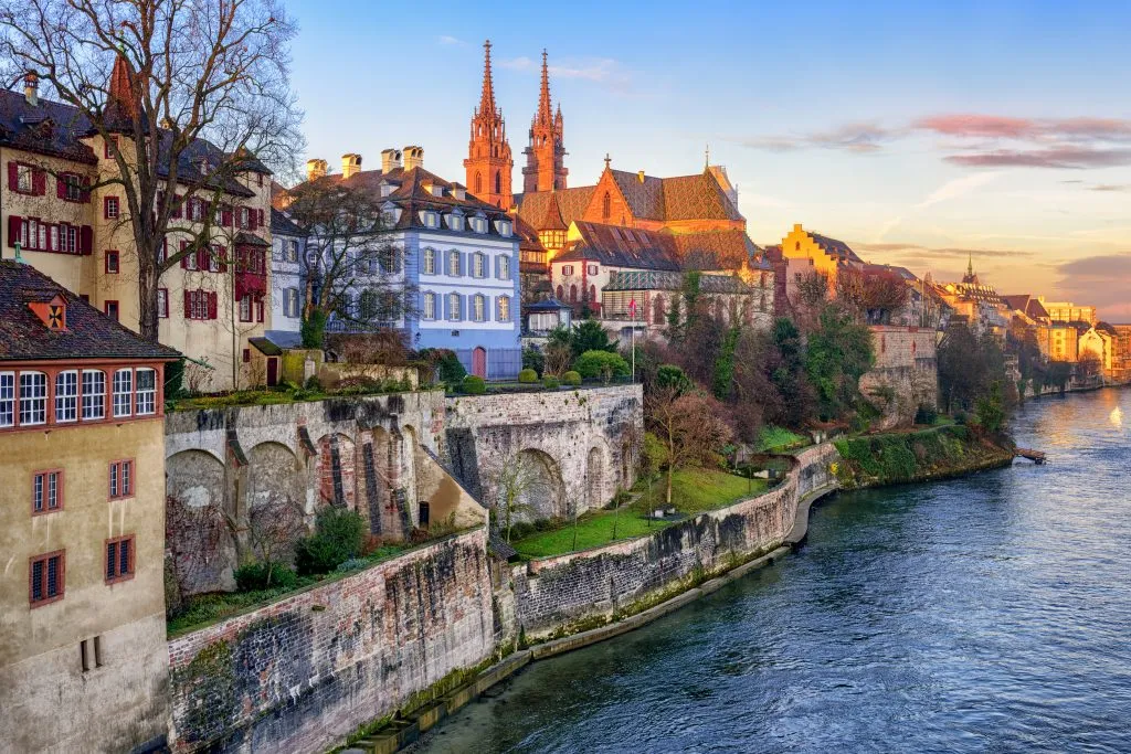 view of old town basel, one of the best cities to visit in switzerland, with river in the foreground