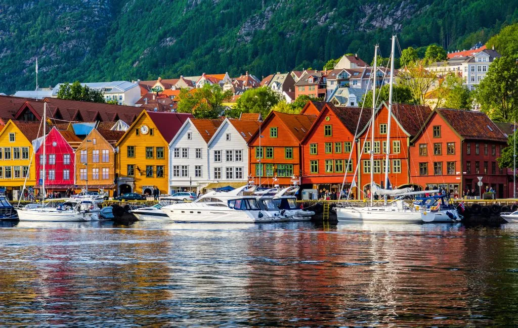 colorful buildings on waterfront in bergen norway with boats in front, as seen from the water. bergen is one of the most romantic cities europe couples getaways