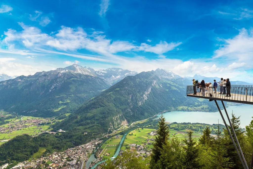 people standing on observation deck overlooking interlaken, one of the top travel destinations switzerland