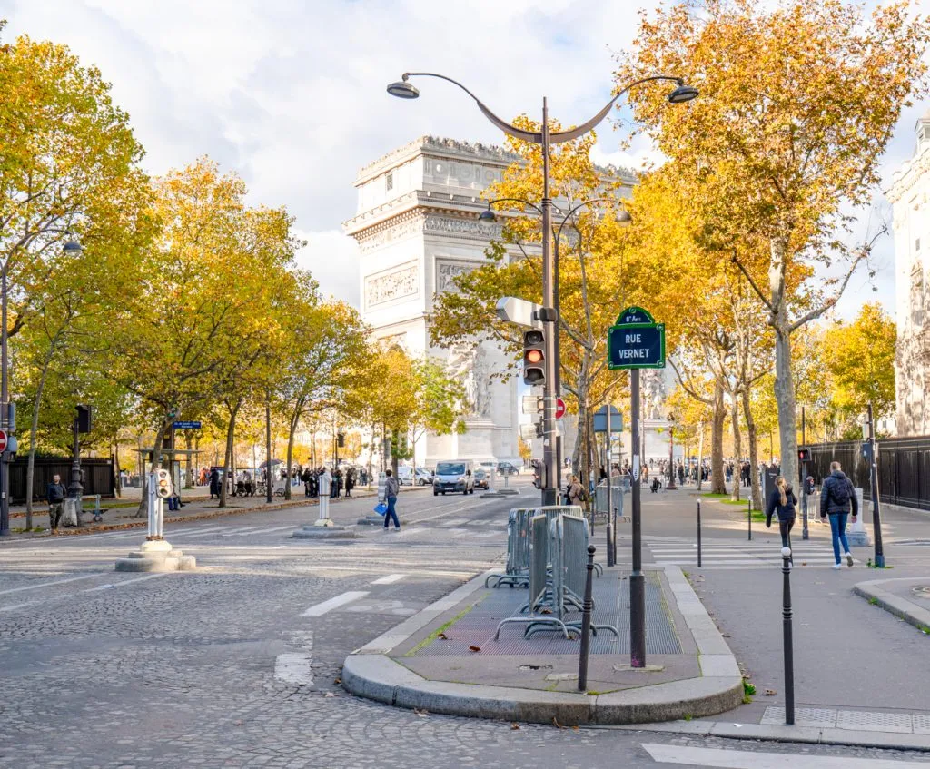 view of arc de triomphe in the distance as seen from a side street with fall foliage in the foreground