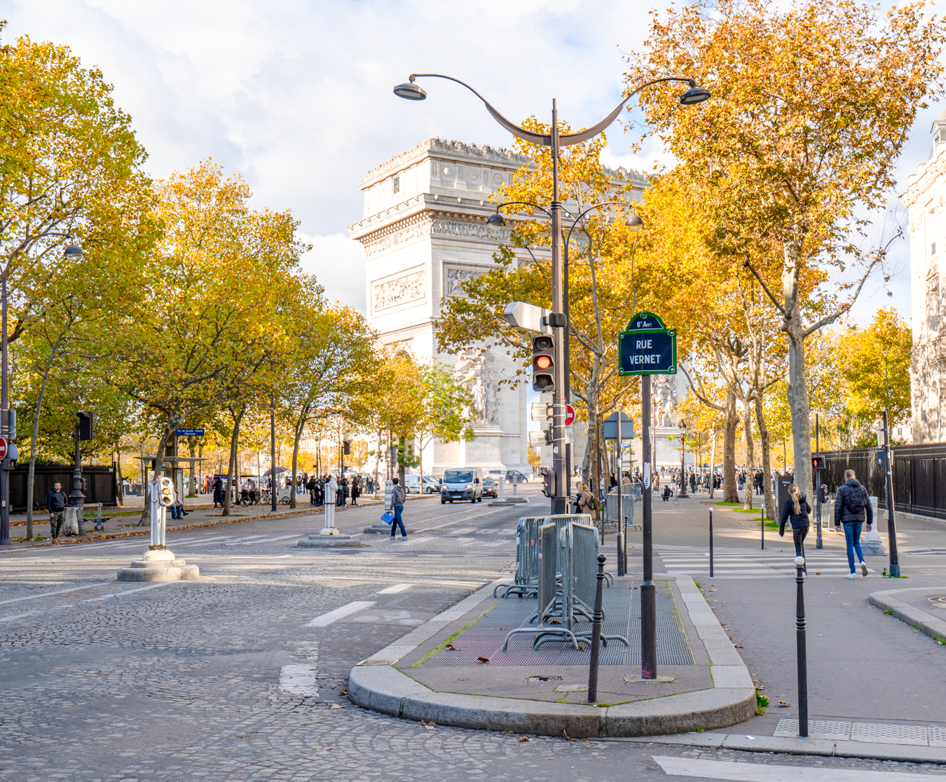 view of arc de triomphe in the distance as seen from a side street with fall foliage in the foreground