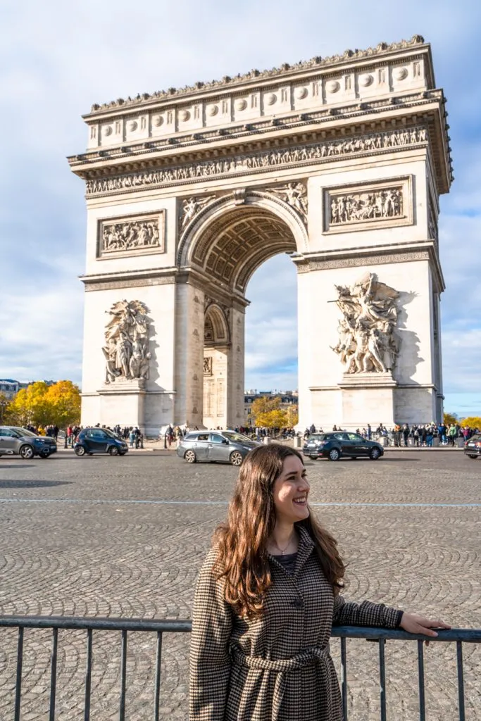 kate storm standing across the street from the paris arc de triomphe