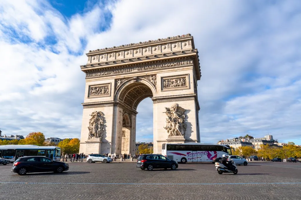 view of the arc de triomphe paris from across the street at an angle on a partly cloudy day