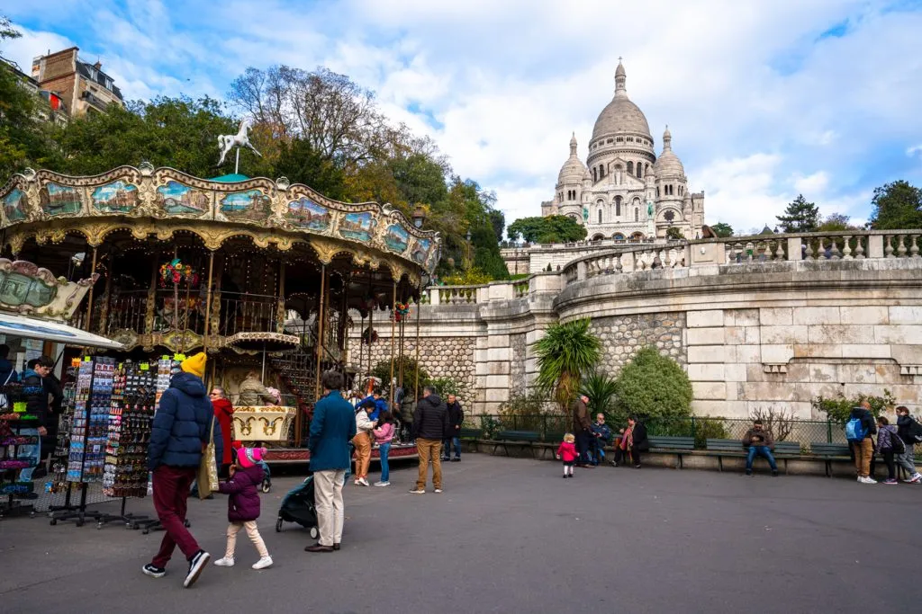 sacre coeur basilica in montmartre with carousel in the foreground