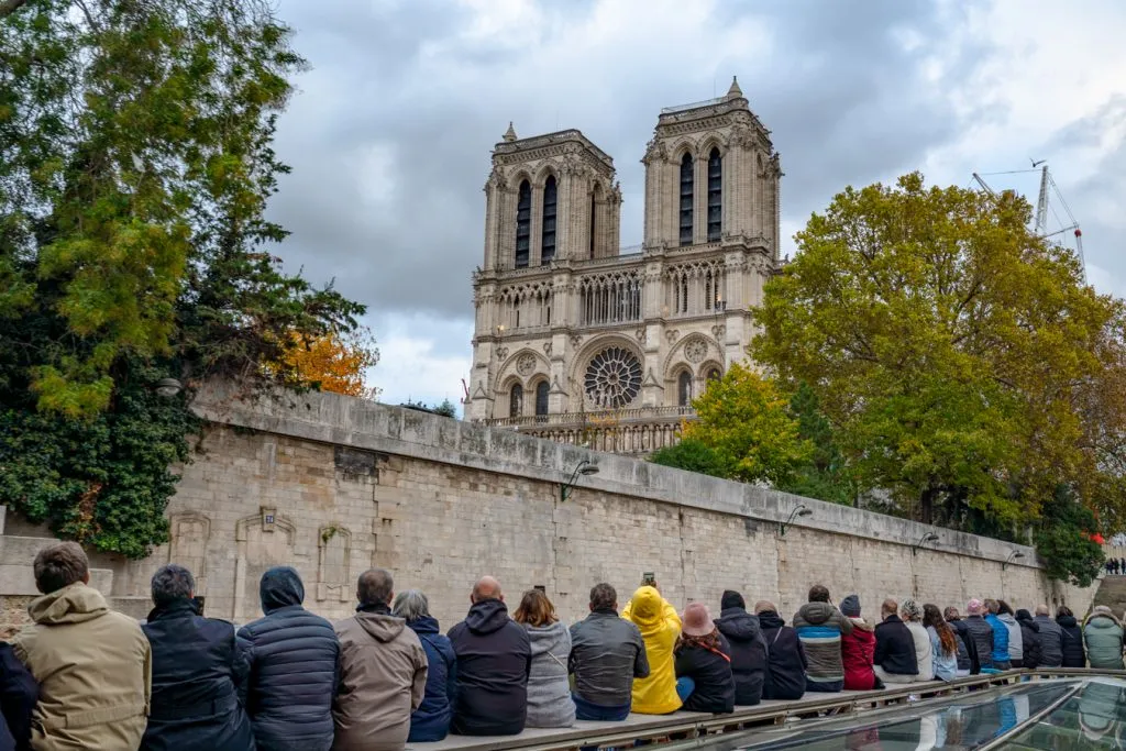 travelers admiring views of notre dame from a seine river cruise during a few days in paris france