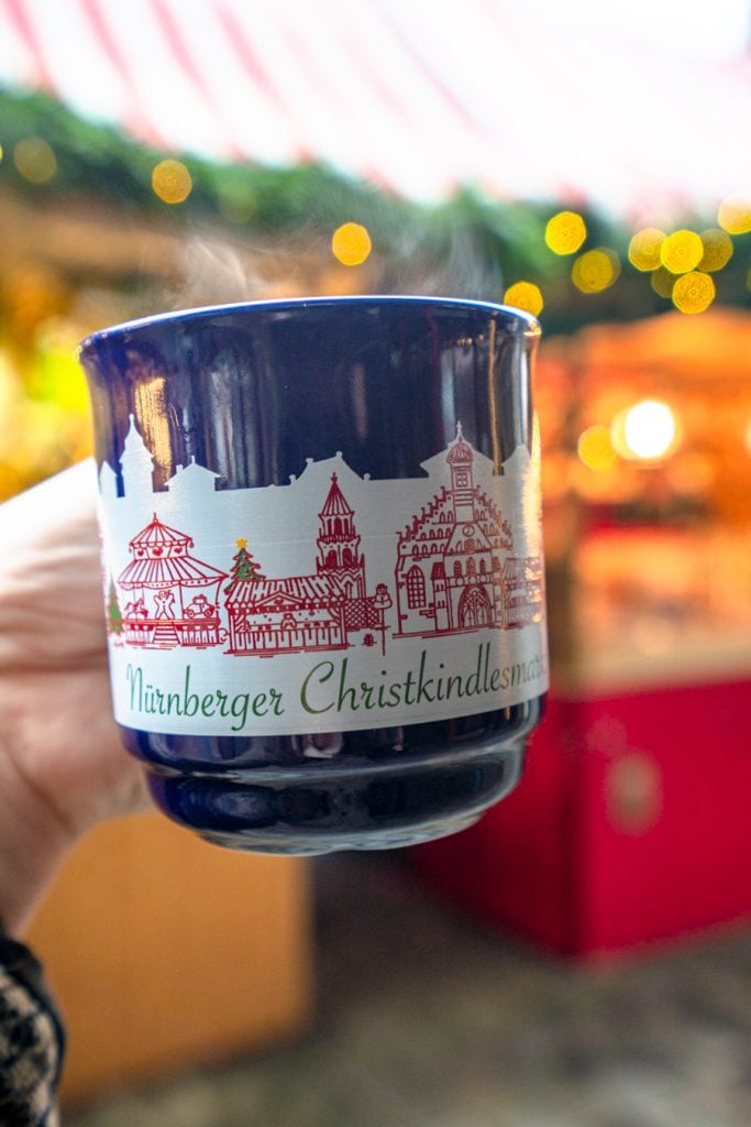 gluhwein mug being held out in front of an advent market stall in nuremberg germany