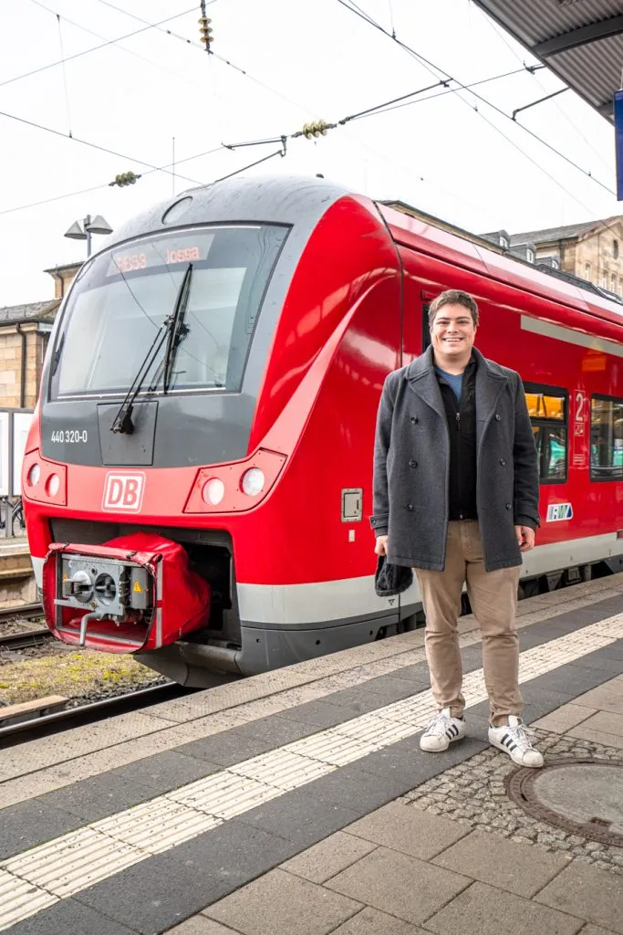 jeremy storm standing in front of a red train in bamberg germany during a christmas vacation in bavaria