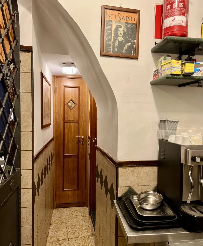 narrow hallway leading to restaurant restrooms in europe