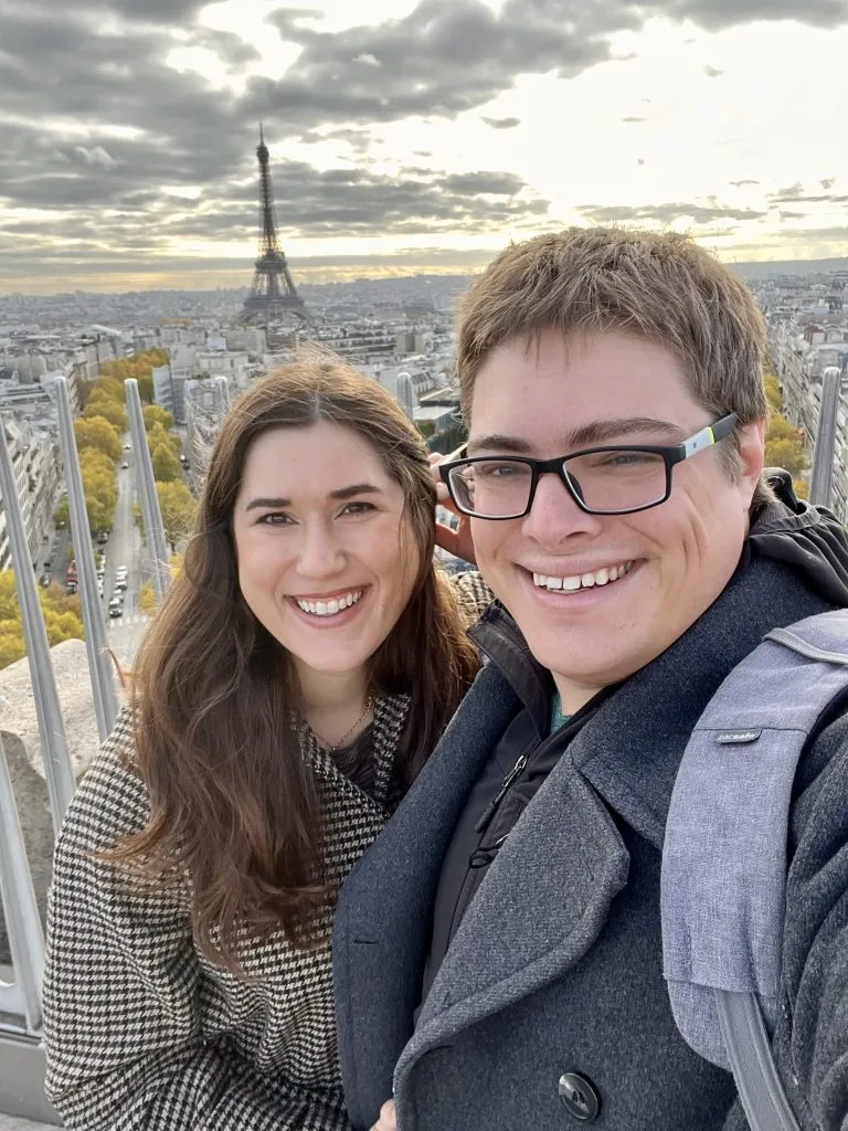 selfie of kate storm and jeremy storm after climb the arc de triomphe paris with eiffel tower in the background