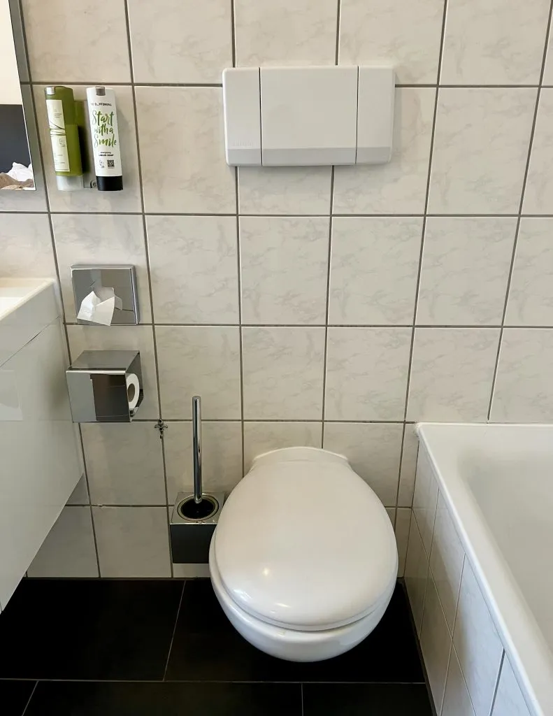 european toilet in a hotel room with bathtub to the right