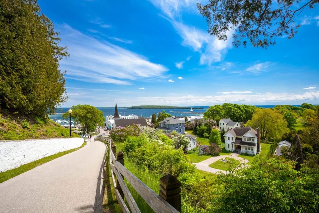 small road on mackinac island with lake huron visible in the distance, one of the best places to visit in usa summer vacation