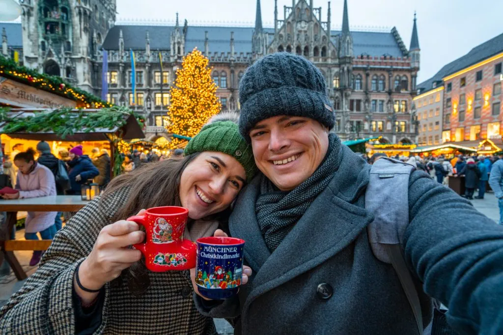 kate storm and jeremy storm holding mugs of gluhwein in one of the christmas markets in bavaria munich germany