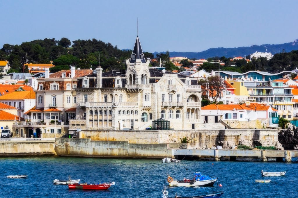 view of estoril portugal from the water with fishing boats in the foreground