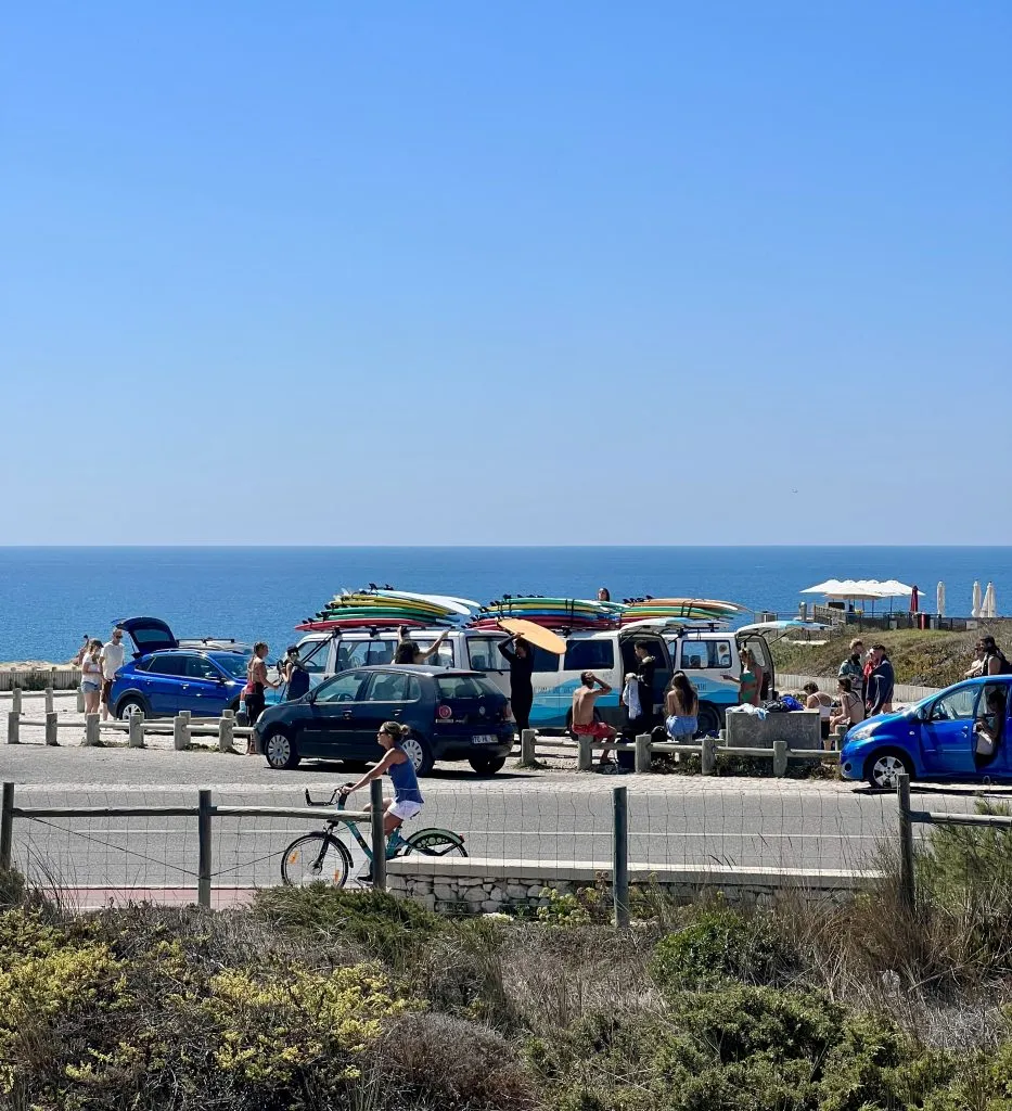 cars and bikes carrying surfboards near praia do guincho, one of the best surf beaches in cascais near lisbon