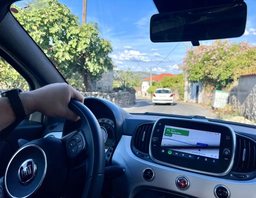 jeremy storm's hand on a steering wheel when driving in portugal and renting a car in europe