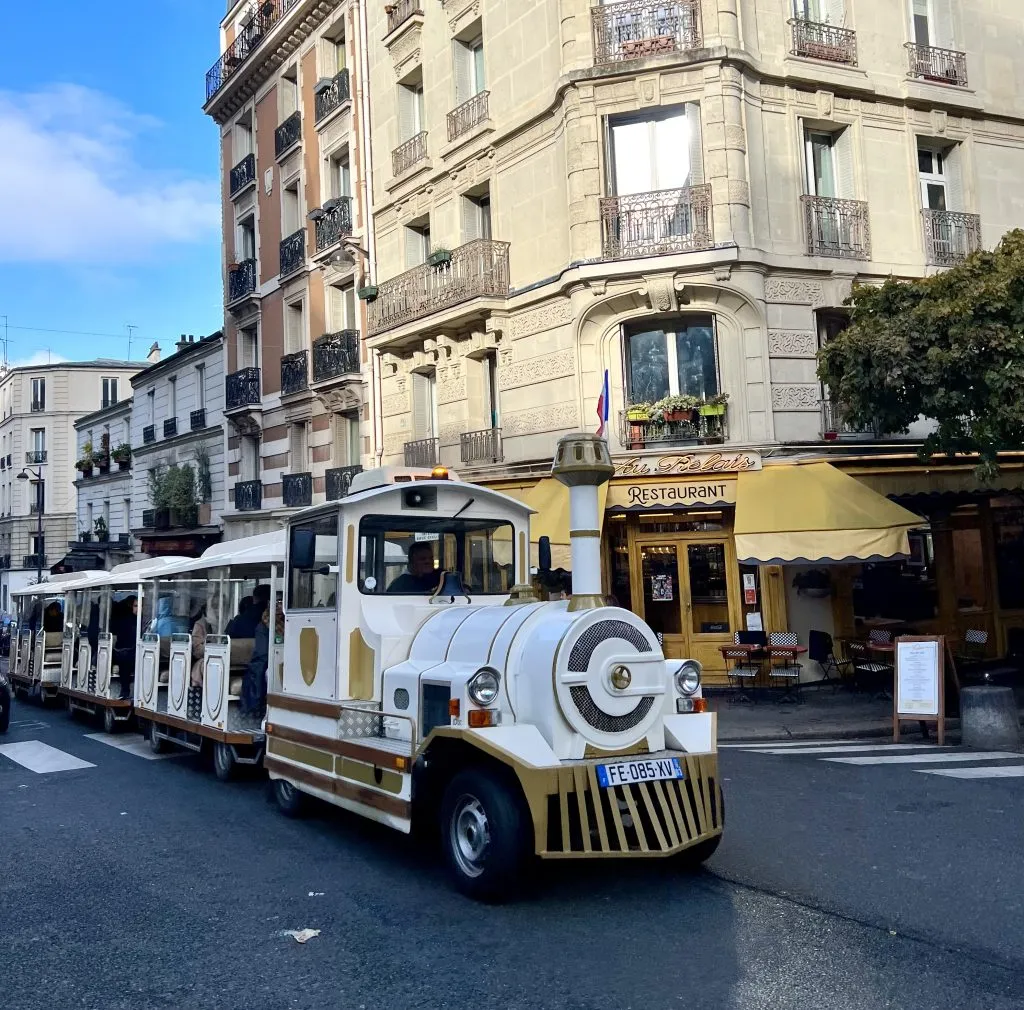 front of the white montmartre tourist train winding through the neighborhood