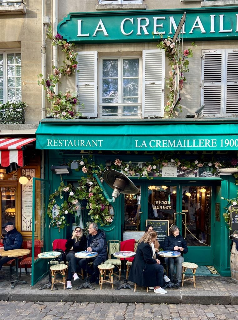 people sitting outside cafe place du tertre