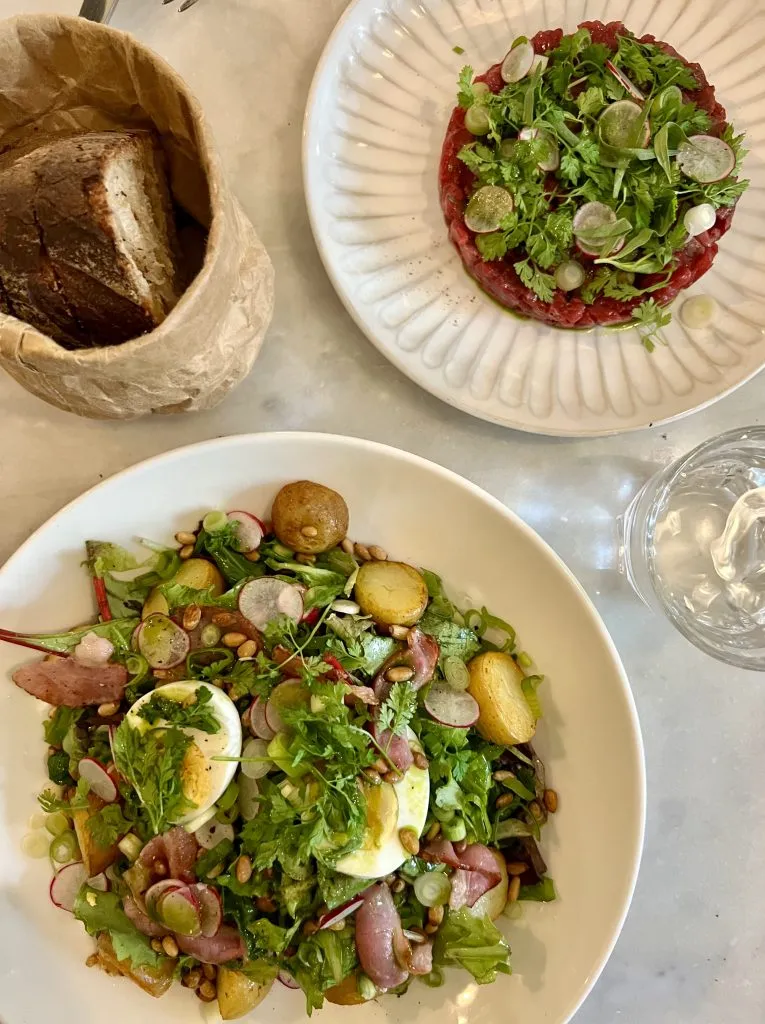 view of lunch salad and boeuf tartare from above at cafe de luce montmartre restaurants