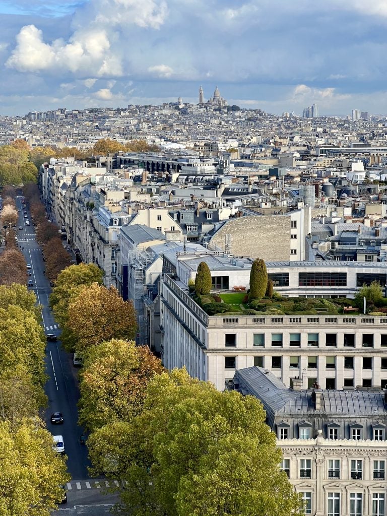view of paris from the top of the arc de triomphe with montmartre in the distance
