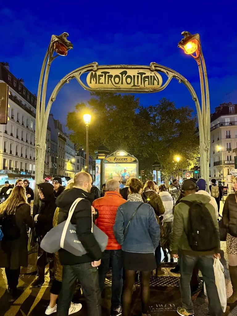 crowd of people walking into anvers metro stop at night in paris