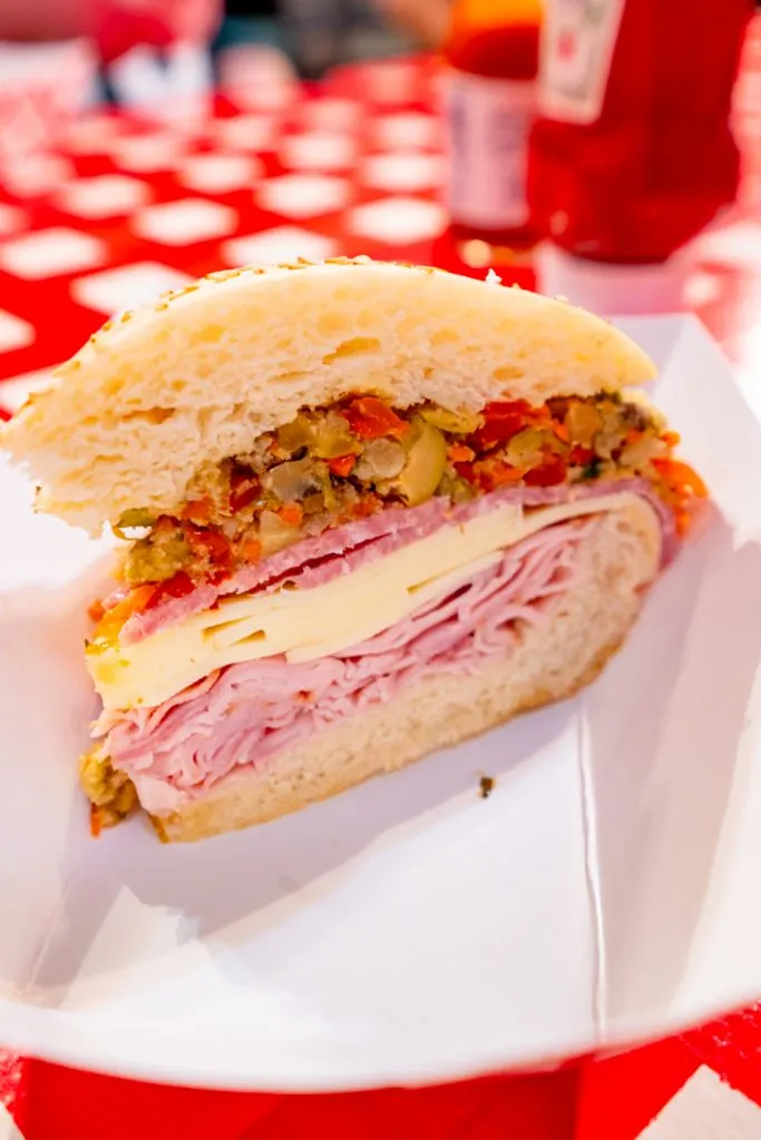 portion of a muffuletta with olive salad visible, which is one of the best new orleans souvenirs to buy