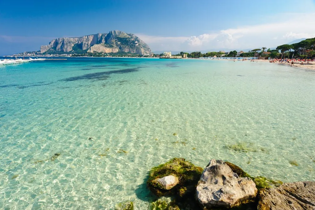 view of clear shallow water at mondello beach near palermo, one of the best beach cities europe