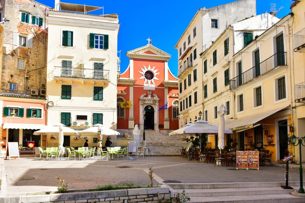colorful building facades in historic center of corfu town greece including a red church