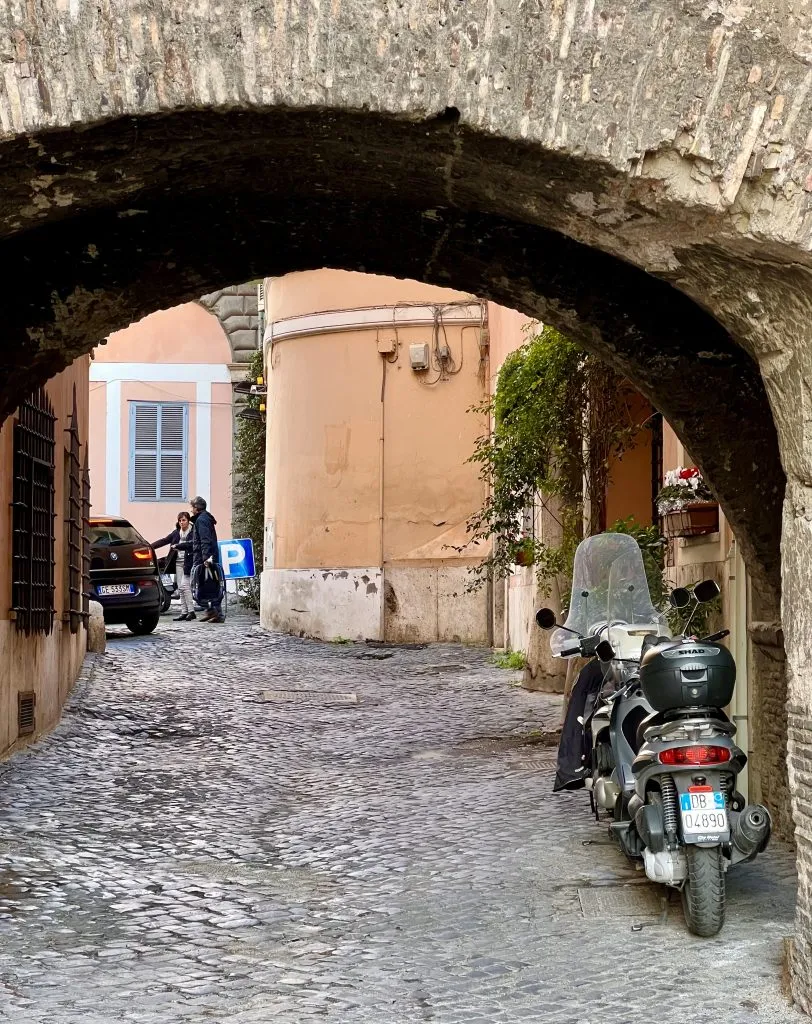 cobblestone street leading into a tunnel as seen on a self guided trastevere walking tour