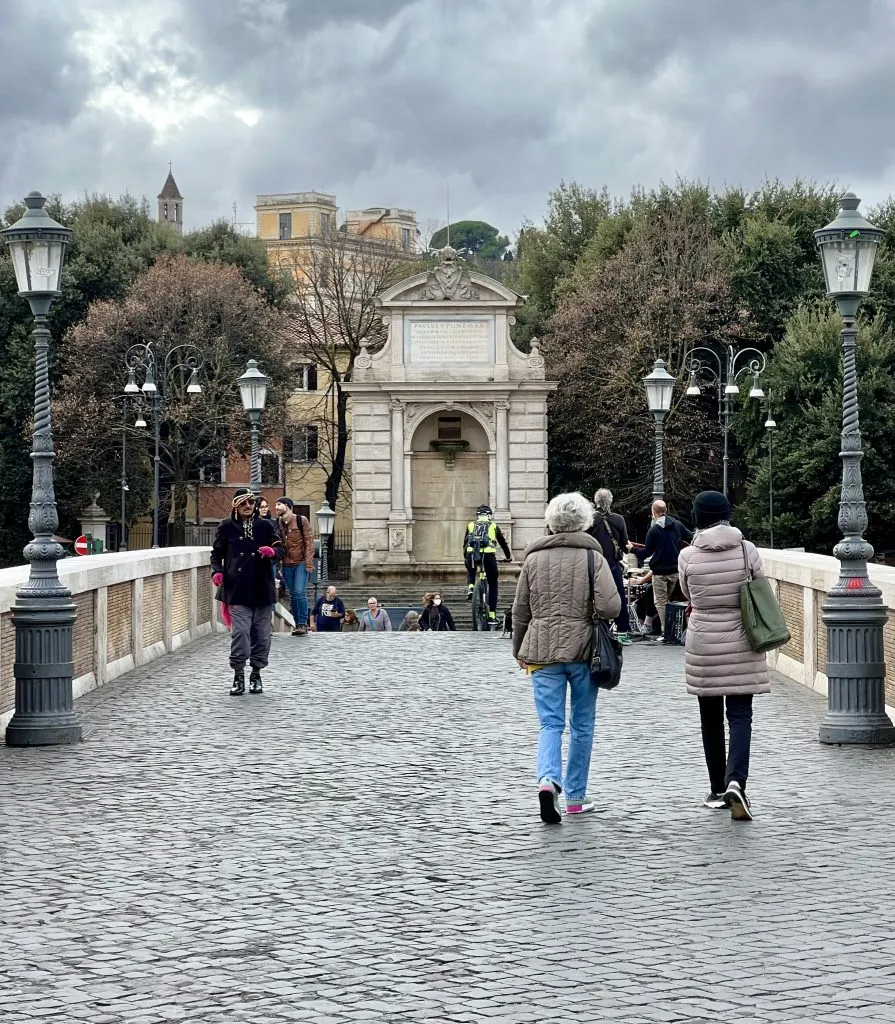 view of people walking toward trastevere piazza trilussa on ponte sisto