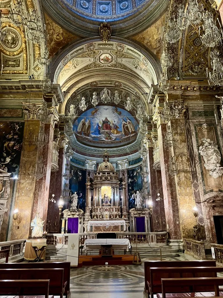 interior of the church of maria della scala in trastevere italy, with chandeliers hanging all around