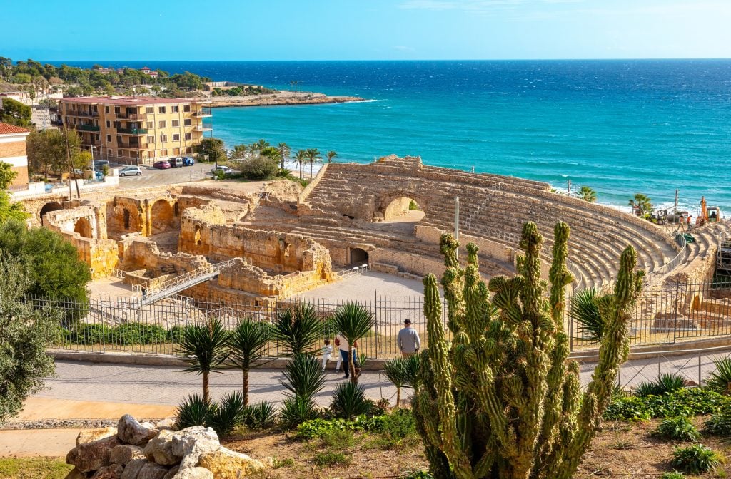 view of roman amphitheater in tarrgona spain with mediterranean sea in the distance