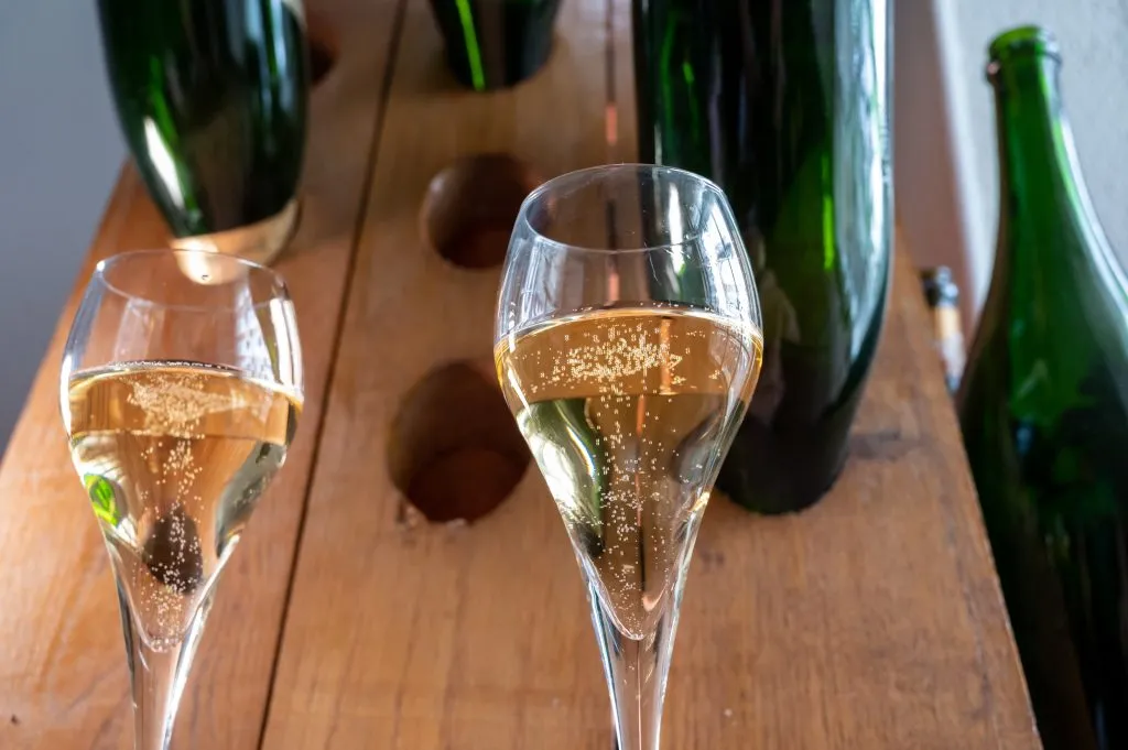 two glasses being poured at a cava tasting on a day tour from barcelona spain