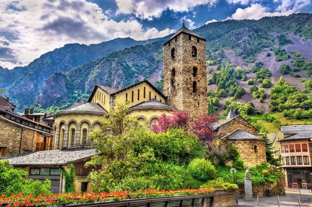 sant esteve church, stone with mountains behind it, in andorra la vella, one of the best day trips barcelona spain