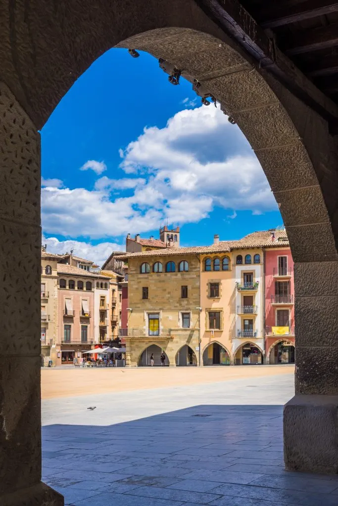 view of a plaza in vic spain as seen through an arch, one of the best day trips barcelona