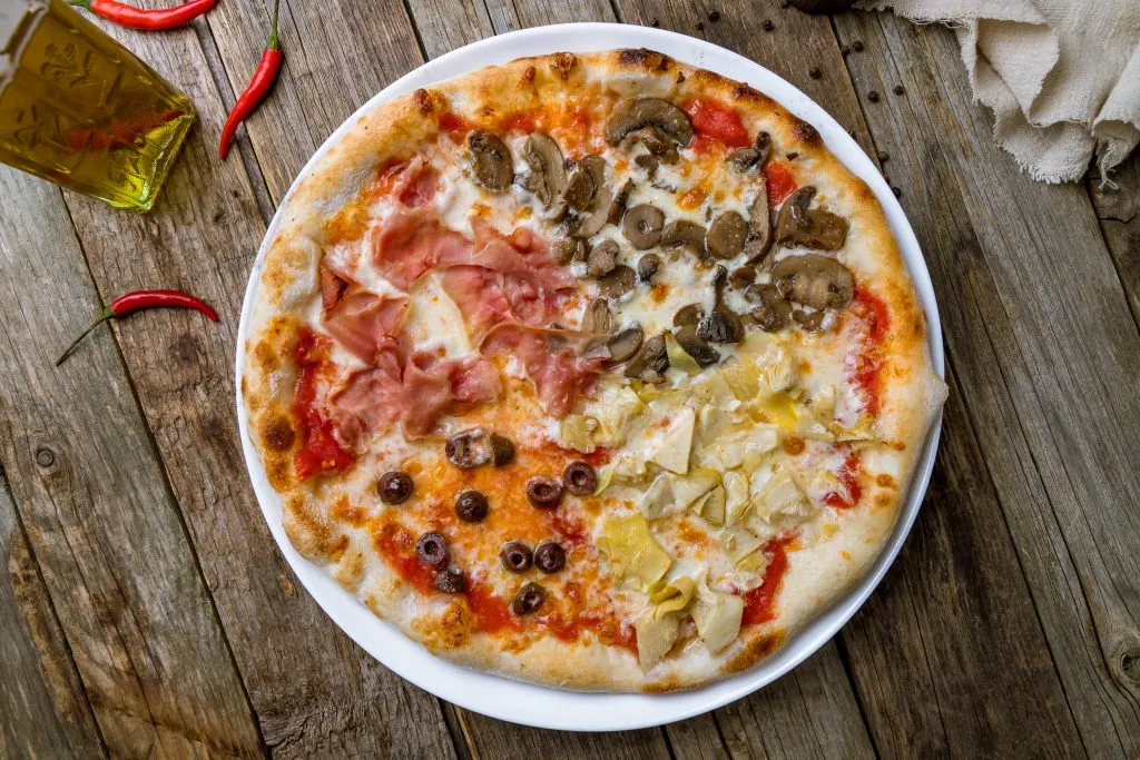 pizza quattro staggioni as seen from above on a wooden table