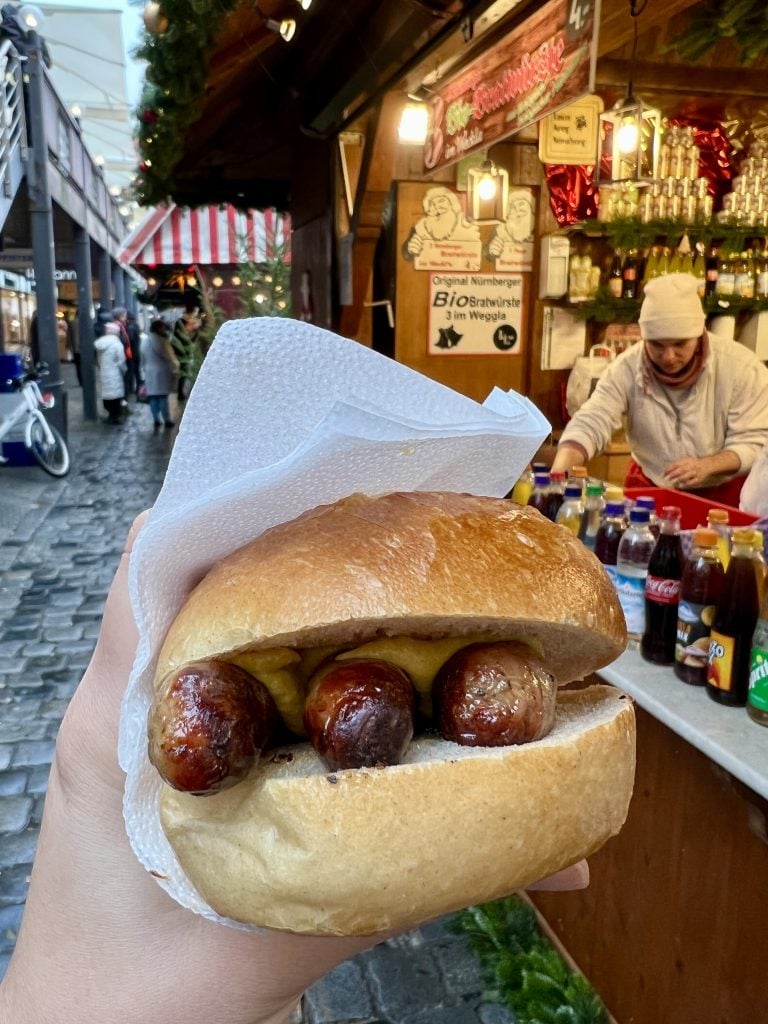 roll of nuremberg sausages being held up at a christmas market in bavaria germany