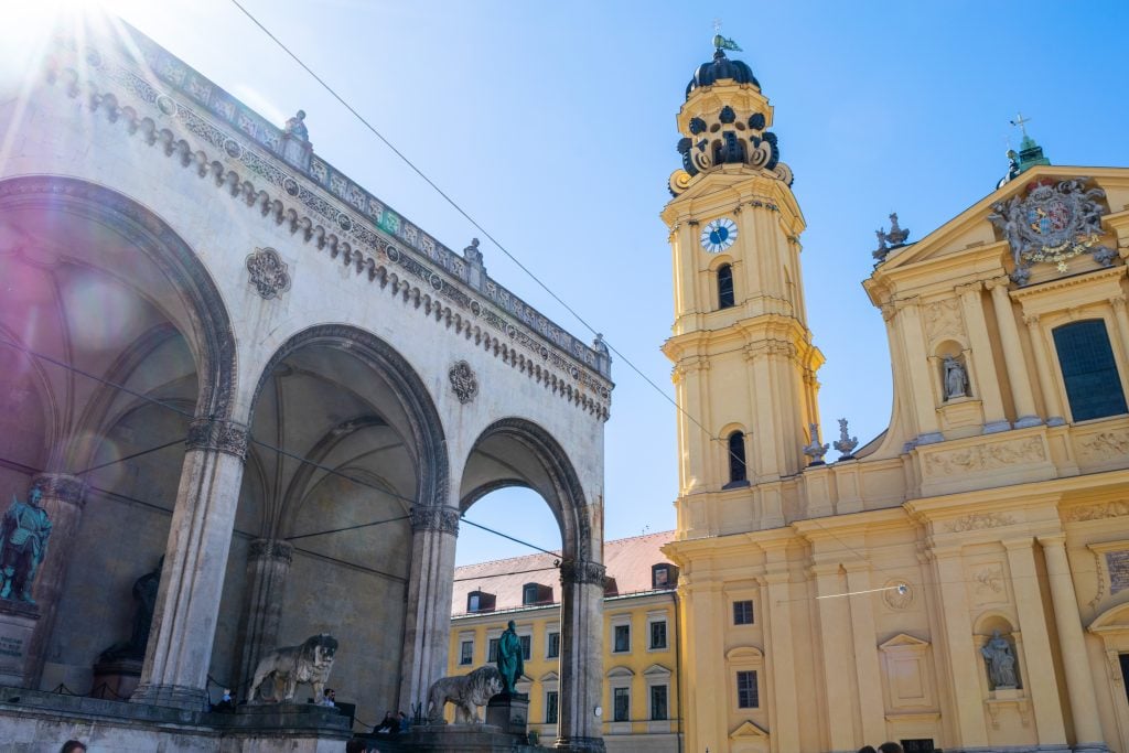 view of Feldherrnhalle and theatine church as seen from an angle on a sunny day when visiting munich for a day