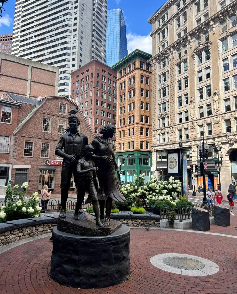 irish famine memorial in boston with old corner bookstore visible behind it, one of the best places to visit in boston in 24 hours