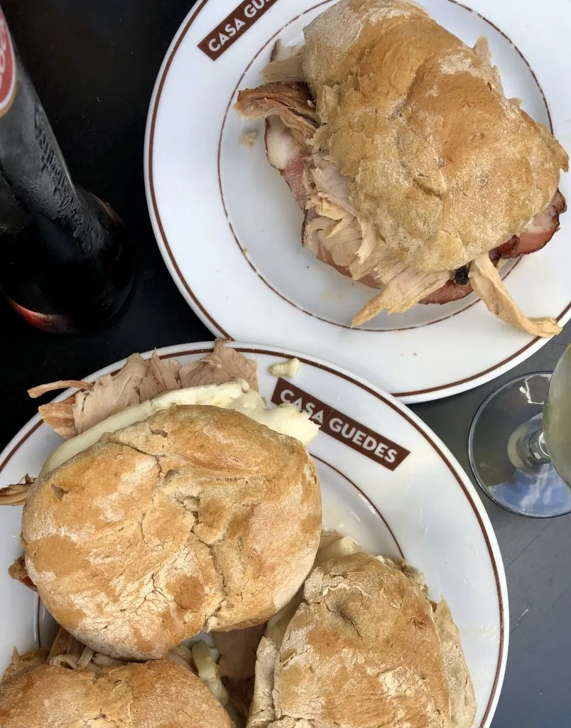 2 plates of roast pork and soft cheese sandwiches from casa guedes in porto