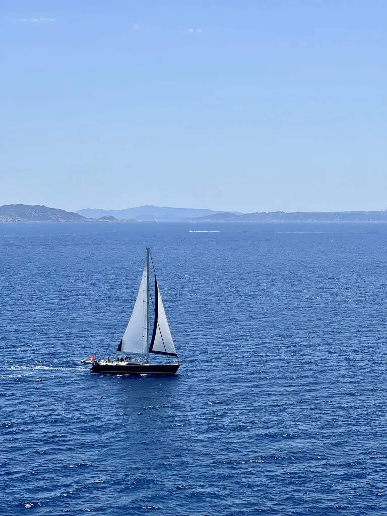 view of a sailboat on the mediterranean sea, seen while taking a ferry from barcelona to rome