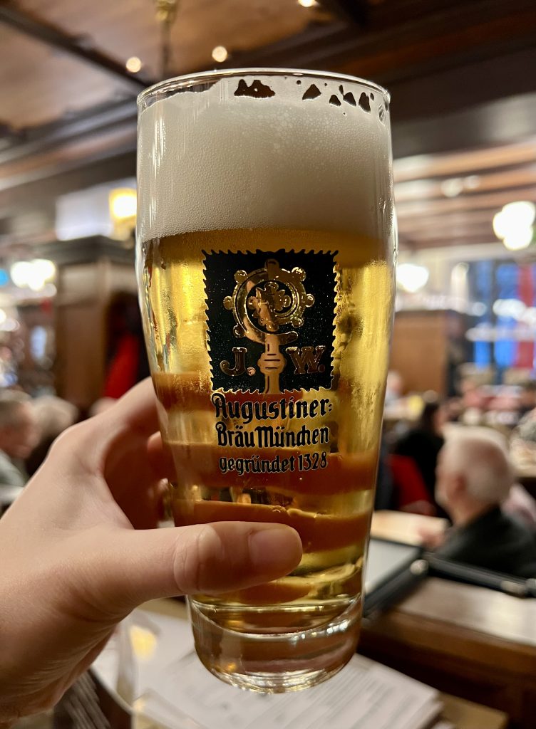 augustiner beer being held up in munich germany restaurant