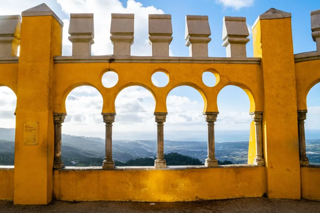 bright yellow terraces of pena palace with portugal countryside seen through them