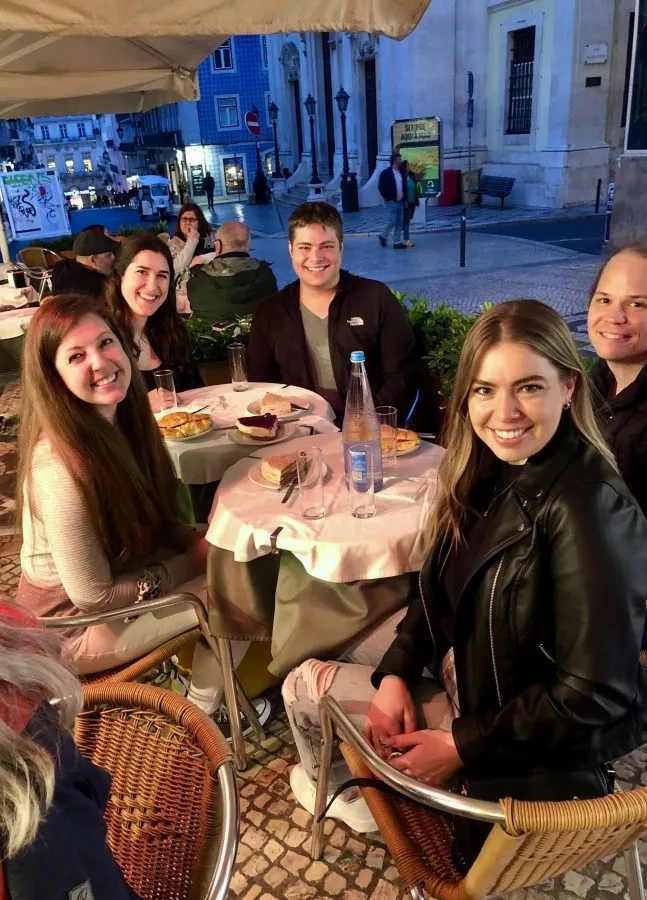 kate storm jeremy storm and friends enjoying dessert on a terrace in lisbon at night