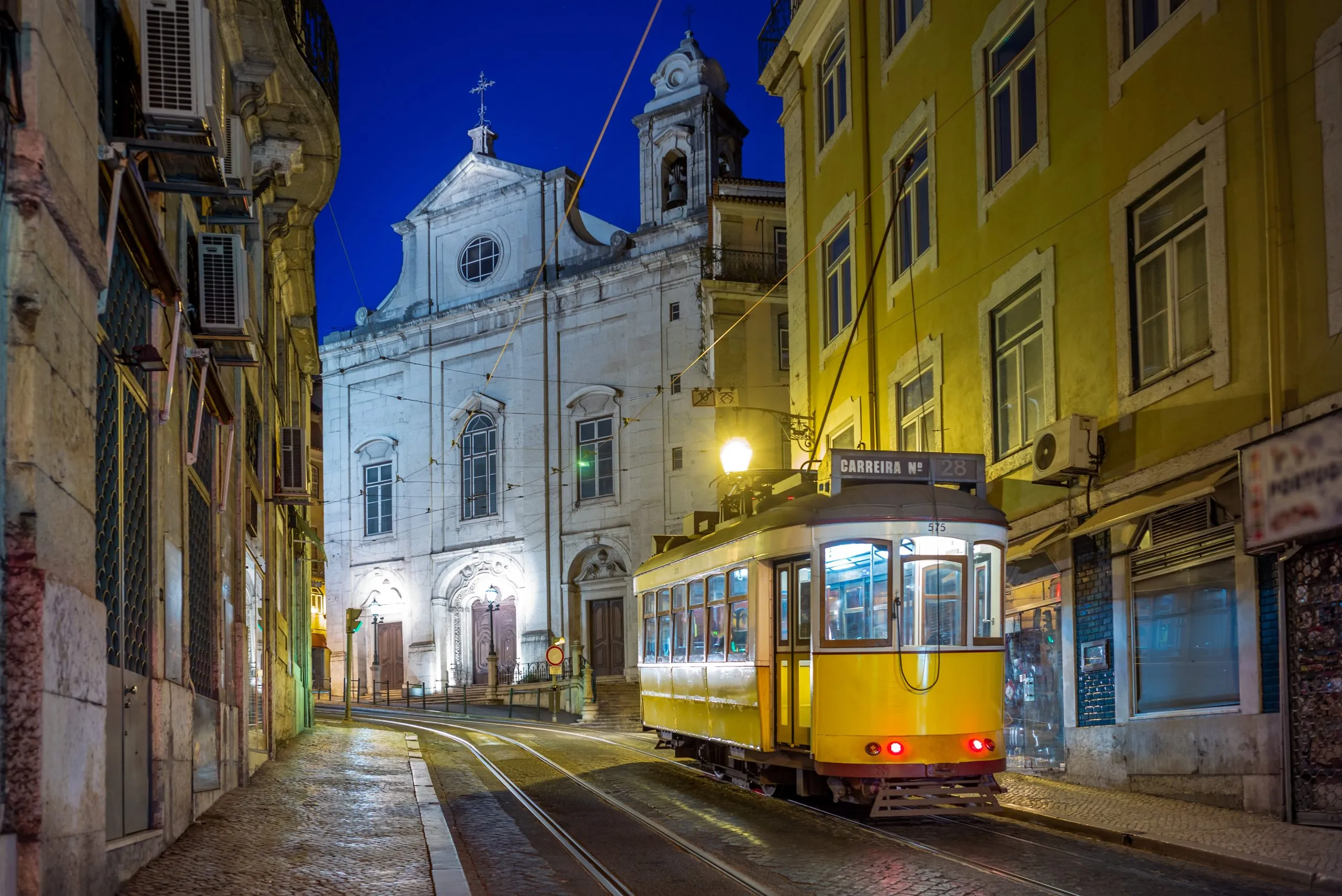lisbon tram 28 passing a church, best things to do in lisbon at night