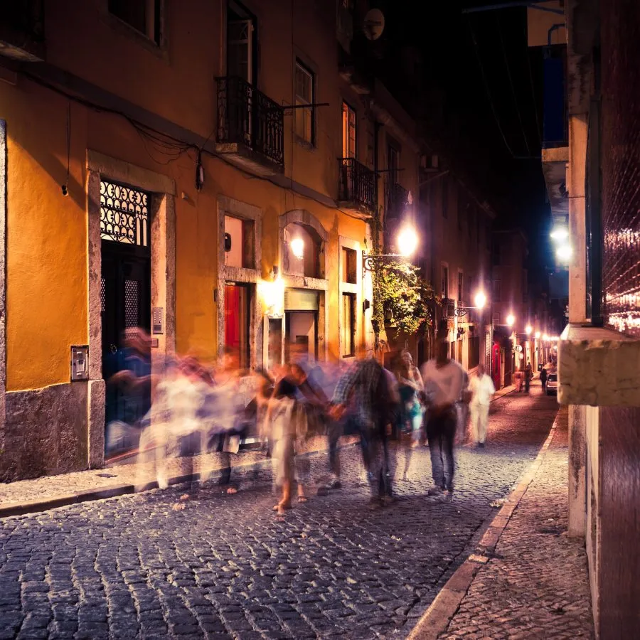 group of travelers walking through lisbon at night