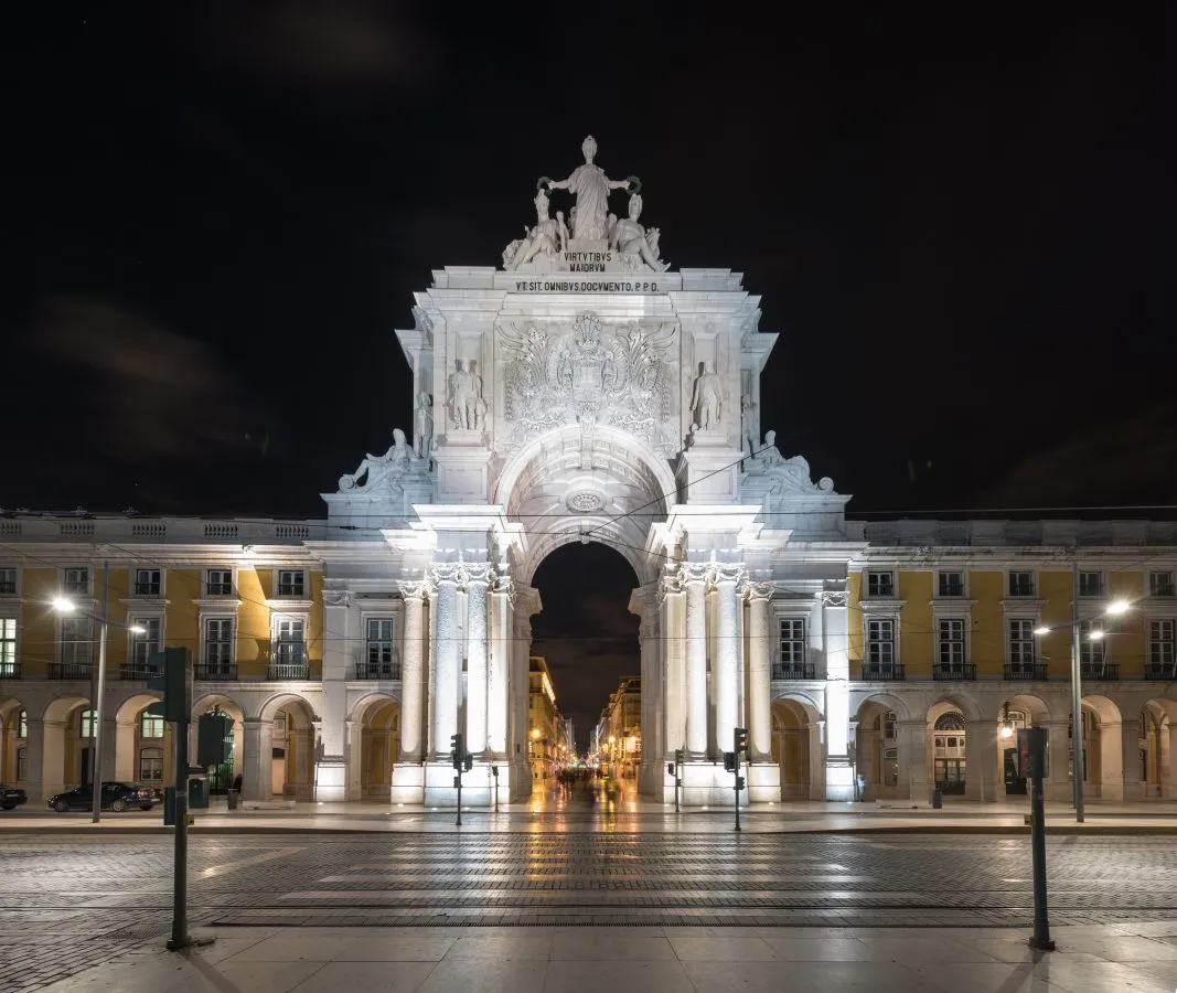 rua augusta arch in at night in lisbon portugal, as seen from praca do comercio