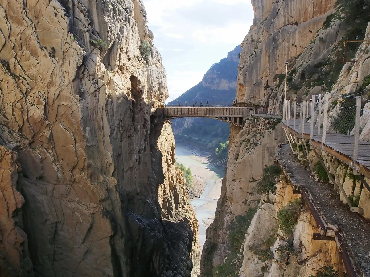narrow bridge crossing a gorge at el caminito del rey, one of the most unique day trips from seville spain