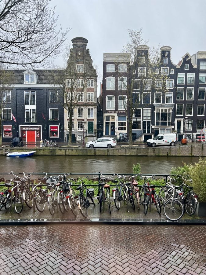 cloudy skies with bikes parked in front of a canal on a rainy day in amsterdam april